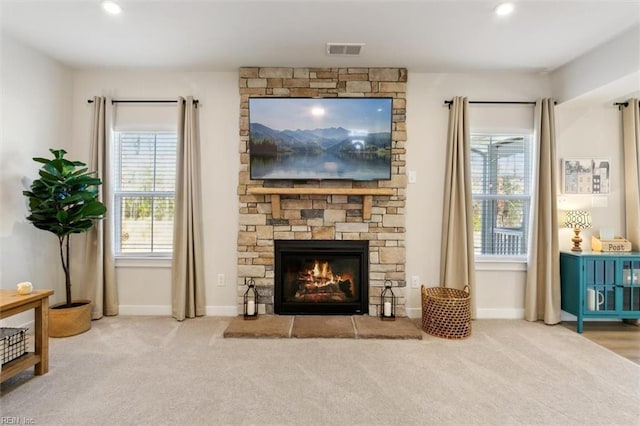 interior space with a stone fireplace, recessed lighting, carpet flooring, visible vents, and baseboards