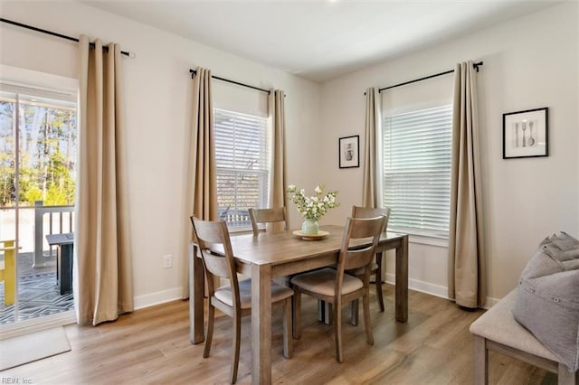 dining area with light wood-type flooring and baseboards