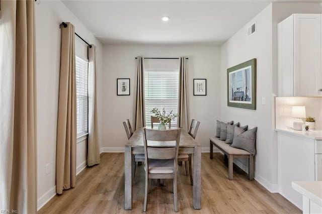 dining room featuring light wood-style floors, baseboards, and visible vents