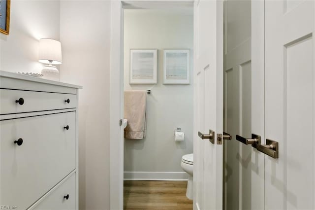 bathroom featuring toilet, baseboards, and wood finished floors