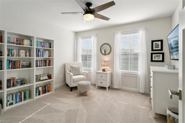 living area with carpet floors, ceiling fan, and baseboards