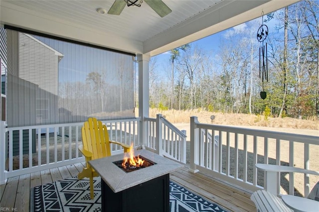 wooden terrace with ceiling fan and a fire pit