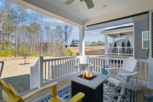 wooden terrace featuring a fire pit and a ceiling fan