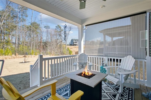 wooden deck featuring an outdoor fire pit and ceiling fan