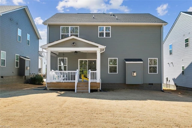 rear view of house with a deck, a yard, and a ceiling fan