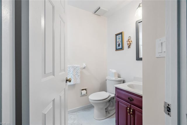 half bath with toilet, baseboards, and vanity