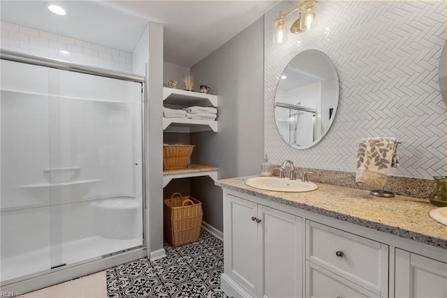 full bath featuring double vanity, tile patterned floors, a sink, a shower stall, and backsplash