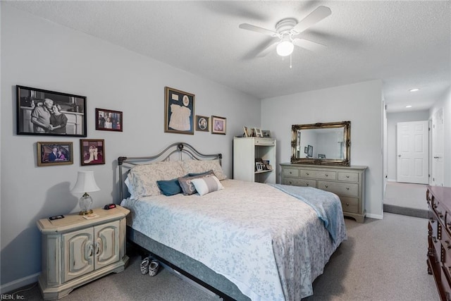 carpeted bedroom with a ceiling fan, a textured ceiling, and baseboards