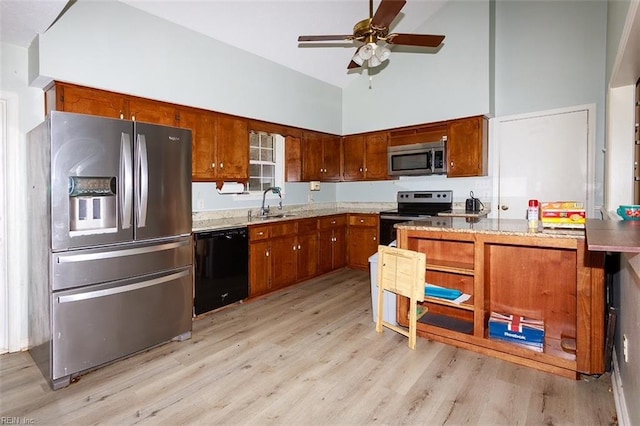 kitchen featuring light wood-style flooring, appliances with stainless steel finishes, a ceiling fan, a sink, and high vaulted ceiling