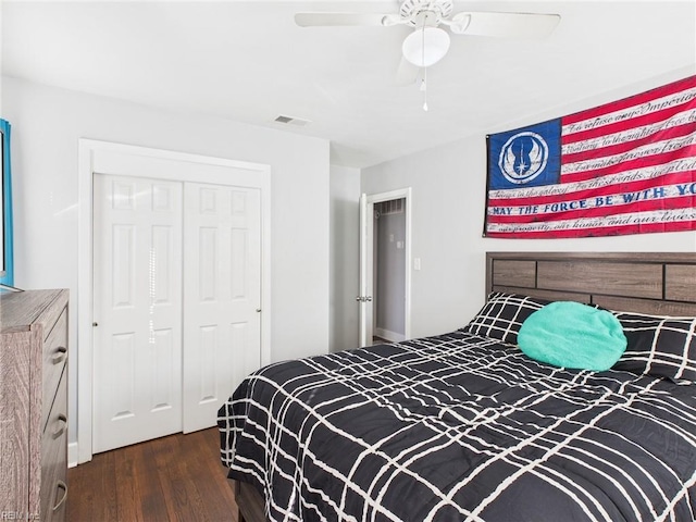 bedroom with dark wood-style floors, ceiling fan, a closet, and visible vents