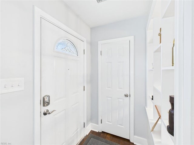 foyer featuring baseboards and dark wood-style flooring