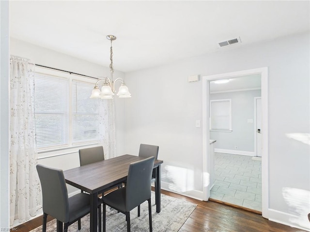 dining area with baseboards, a notable chandelier, visible vents, and dark wood-style flooring