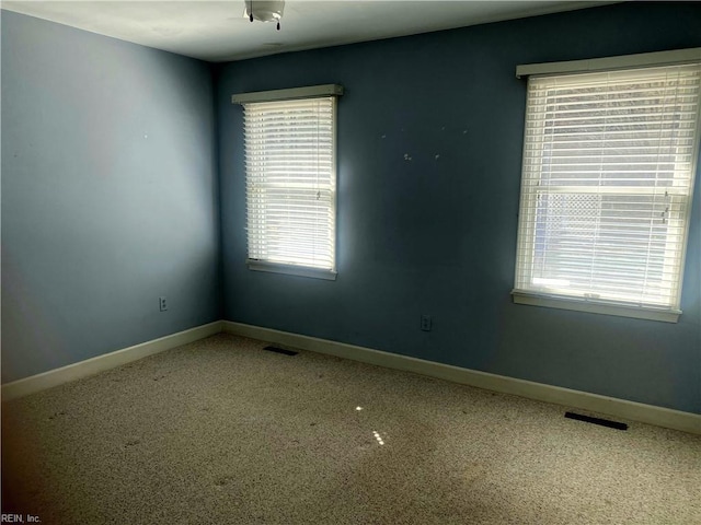 spare room featuring visible vents and baseboards