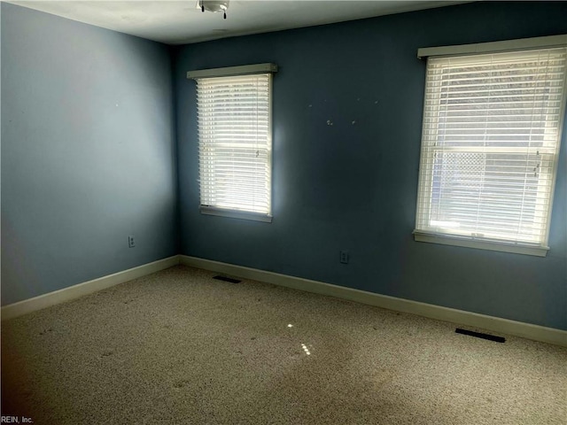 empty room featuring visible vents and baseboards