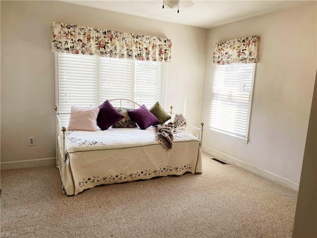 bedroom with light colored carpet, visible vents, and baseboards