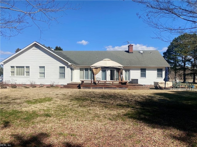 rear view of house with a wooden deck, a chimney, crawl space, a gazebo, and a yard