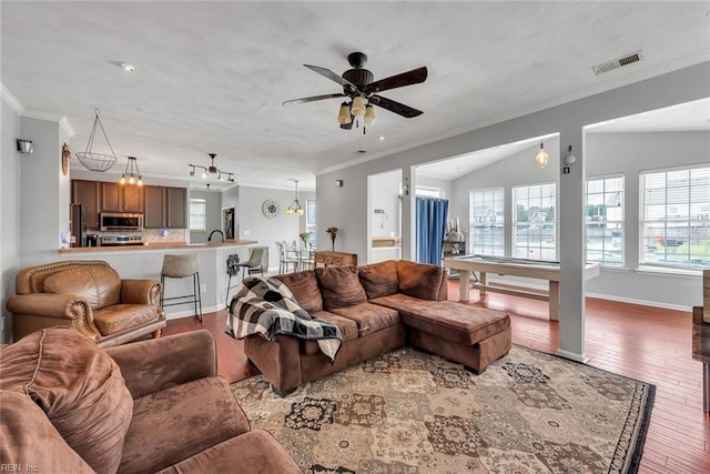 living room featuring a ceiling fan, visible vents, ornamental molding, and wood finished floors