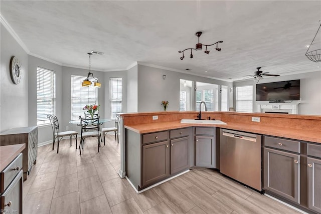 kitchen featuring visible vents, hanging light fixtures, gray cabinets, stainless steel dishwasher, and a sink