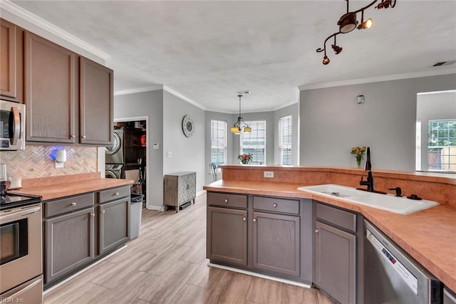 kitchen featuring tasteful backsplash, appliances with stainless steel finishes, gray cabinets, and a sink