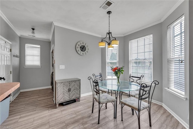 dining area with wood finish floors, a notable chandelier, visible vents, ornamental molding, and baseboards