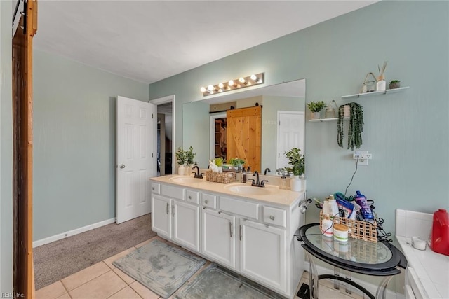 bathroom featuring double vanity, tile patterned floors, a sink, and baseboards