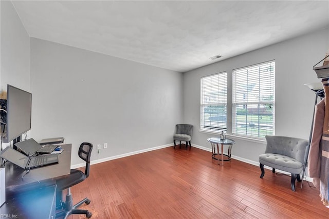 office space with visible vents, baseboards, and wood finished floors