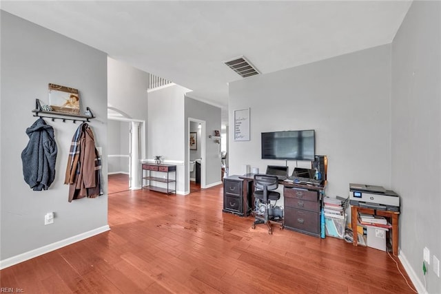 home office with baseboards, visible vents, and wood finished floors