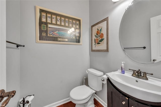 bathroom featuring vanity, toilet, and baseboards