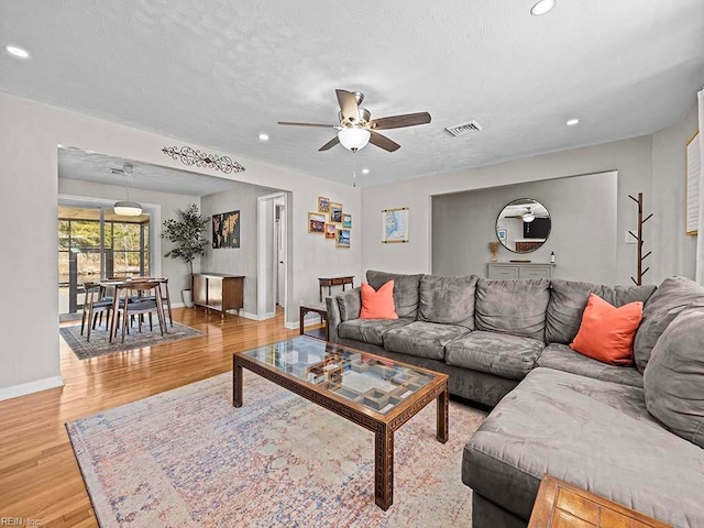 living area featuring light wood-style floors, recessed lighting, and visible vents