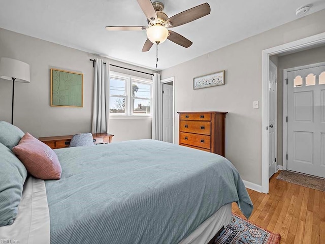 bedroom with light wood-style floors, baseboards, and a ceiling fan