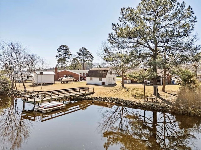 exterior space featuring a boat dock, a water view, and an outdoor structure