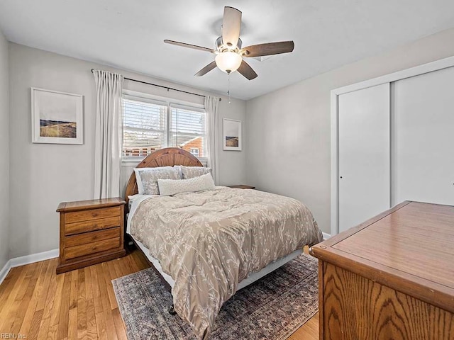 bedroom featuring light wood-style flooring, baseboards, ceiling fan, and a closet