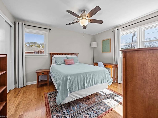 bedroom featuring light wood-type flooring, baseboards, and a ceiling fan