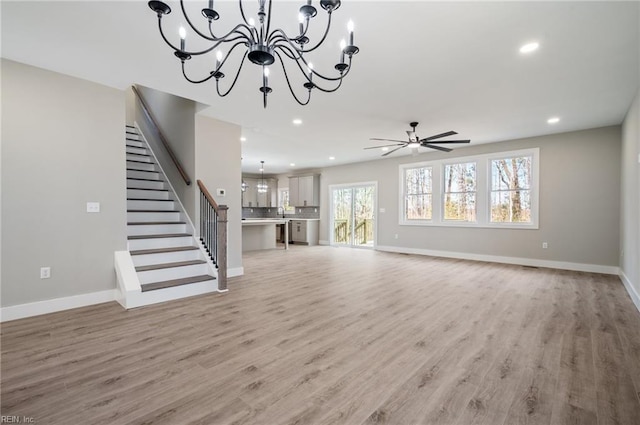 unfurnished living room featuring recessed lighting, stairway, light wood-type flooring, and baseboards