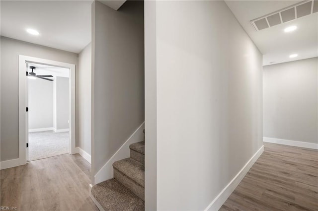 hallway with wood finished floors, visible vents, and recessed lighting