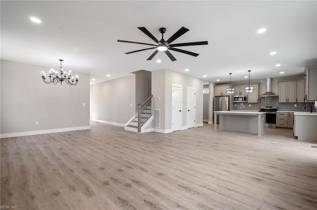 unfurnished living room featuring light wood-style flooring, recessed lighting, visible vents, baseboards, and stairs