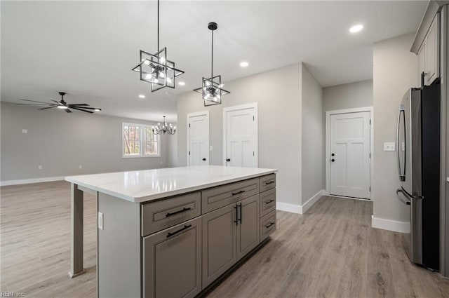 kitchen featuring baseboards, freestanding refrigerator, gray cabinets, light wood-type flooring, and recessed lighting