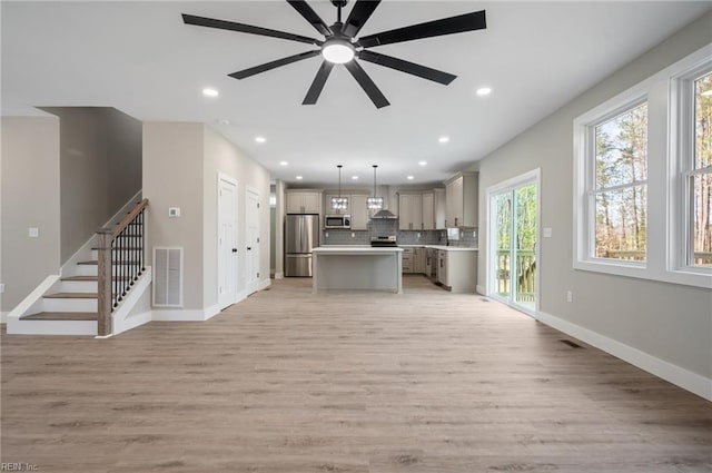 kitchen featuring visible vents, open floor plan, light countertops, appliances with stainless steel finishes, and backsplash