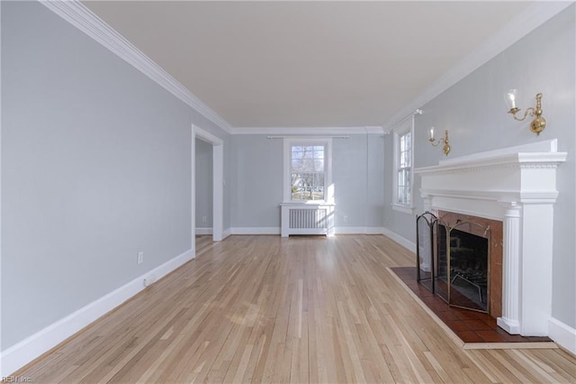 unfurnished living room with crown molding, light wood-style flooring, radiator heating unit, and baseboards