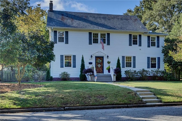 colonial home with a front yard and a chimney