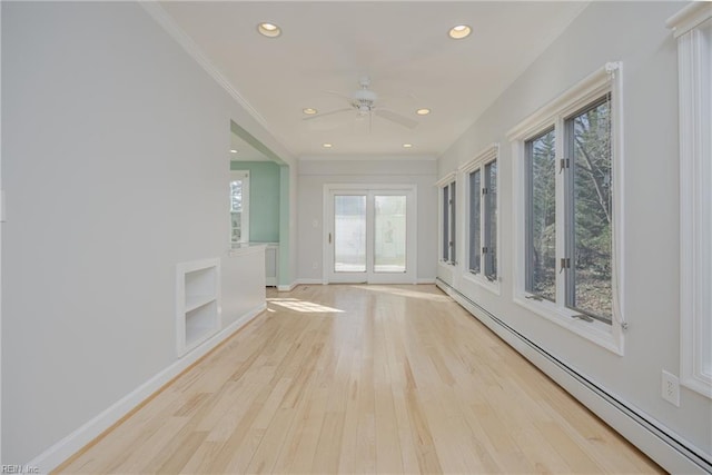 interior space with a baseboard heating unit and a ceiling fan