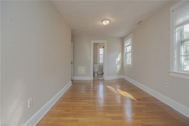 empty room with baseboards and light wood finished floors