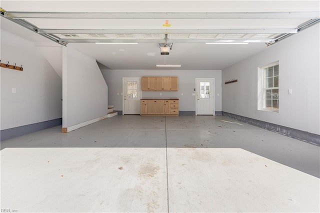 garage with a garage door opener and baseboards