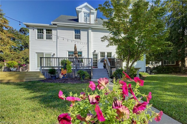 rear view of house featuring a wooden deck and a yard