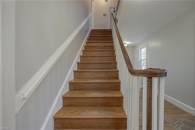 stairway with baseboards and wood finished floors