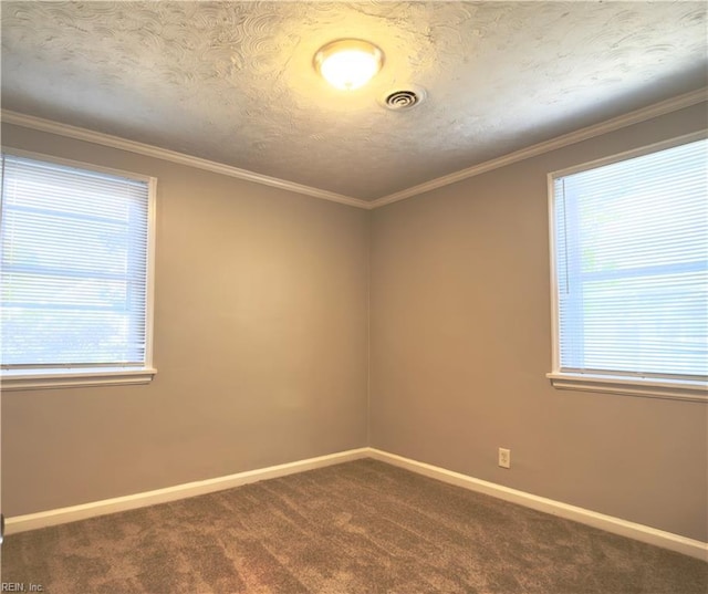 unfurnished room with baseboards, visible vents, dark carpet, and ornamental molding