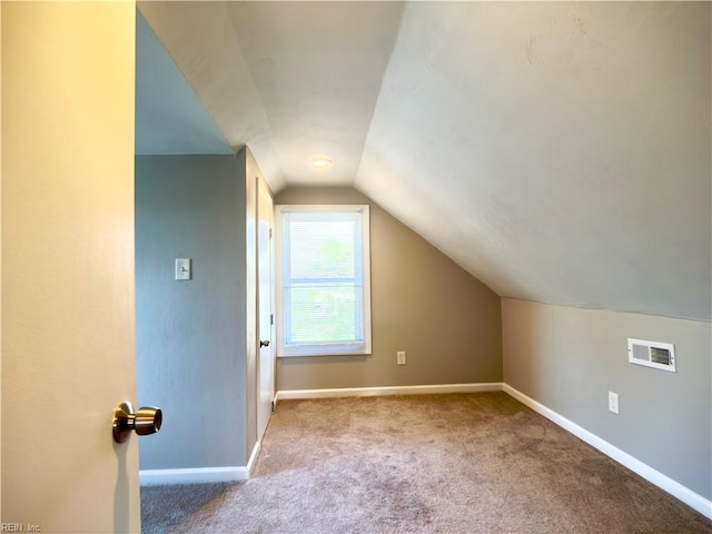 bonus room featuring baseboards, visible vents, vaulted ceiling, and carpet flooring