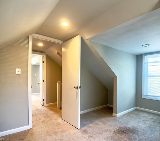 bonus room featuring lofted ceiling, baseboards, and light colored carpet