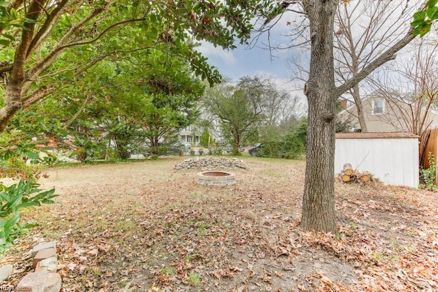 view of yard with a fire pit and an outdoor structure