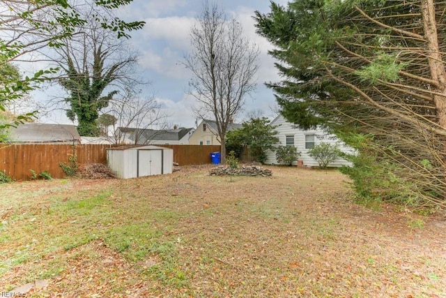 view of yard with a storage shed, an outdoor structure, and fence